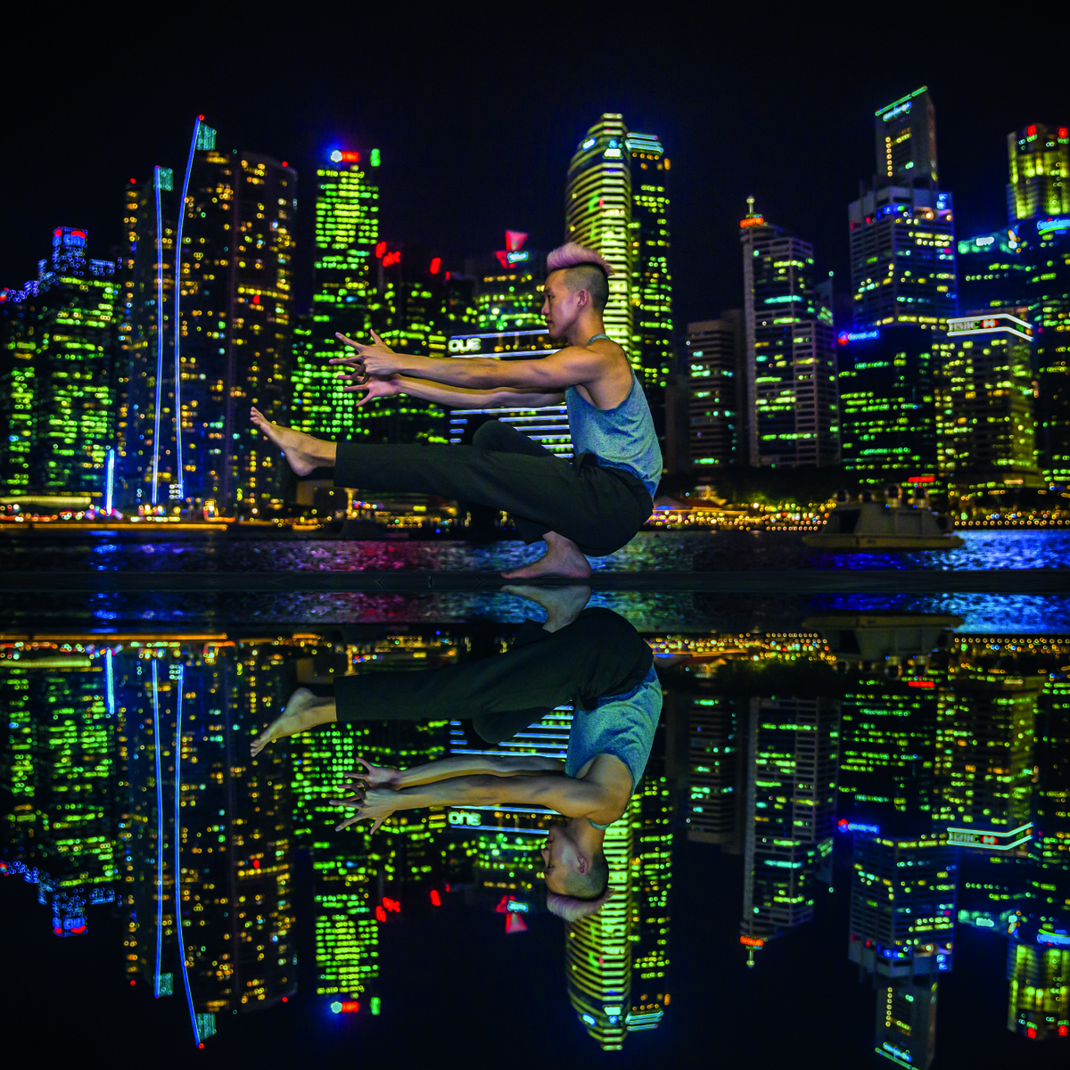 Heavily tattooed couple embracing in yoga pose, on city bridge, Yoga and the City in red font above