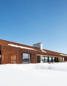 Contemporary flat roof building near lake and autumn trees, Inspired by Place Architects CLB in brown font above by Oro Editions.