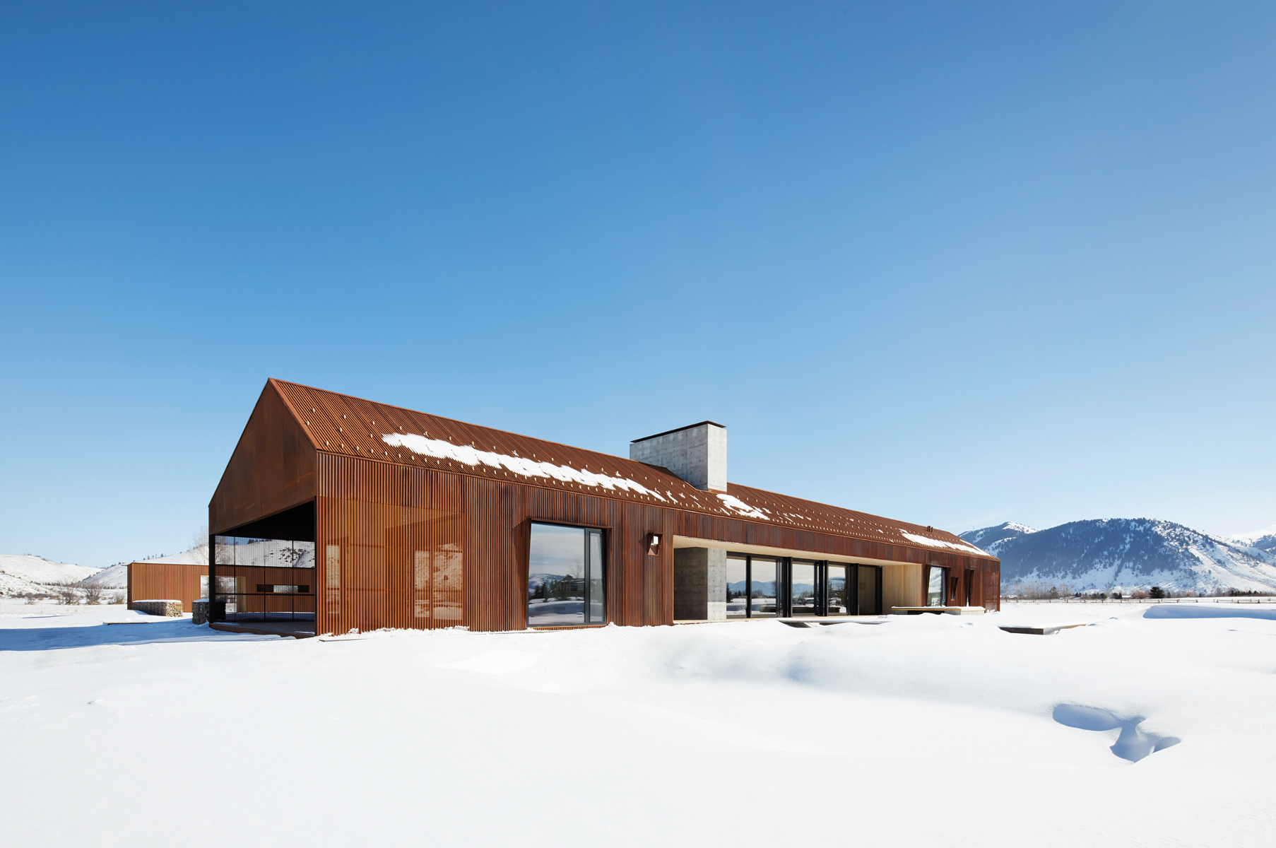 Contemporary flat roof building near lake and autumn trees, Inspired by Place Architects CLB in brown font above by Oro Editions.