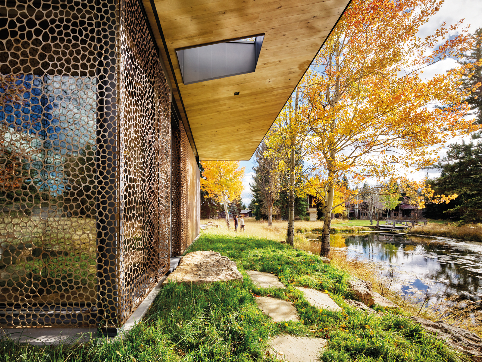 Contemporary flat roof building near lake and autumn trees, Inspired by Place Architects CLB in brown font above by Oro Editions.