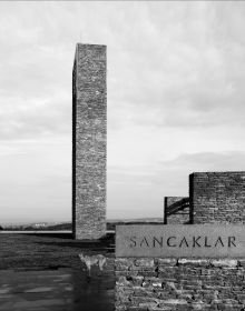 Low angled shot of interior building, Emre Arolat Scent of the Trace in white font above.