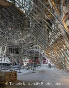 Modern curved wood and glass architectural structure, Library at Stoa Snohetta Public Space and Academic Mission in the Charles Library in white font.