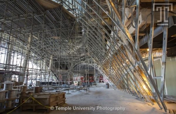Modern curved wood and glass architectural structure, Library at Stoa Snohetta Public Space and Academic Mission in the Charles Library in white font.