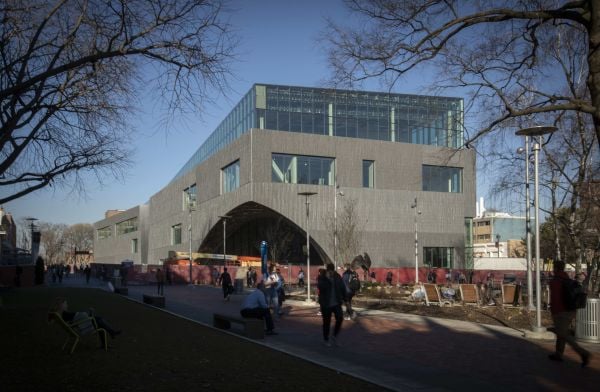 Modern curved wood and glass architectural structure, Library at Stoa Snohetta Public Space and Academic Mission in the Charles Library in white font.