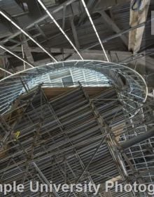Modern curved wood and glass architectural structure, Library at Stoa Snohetta Public Space and Academic Mission in the Charles Library in white font.