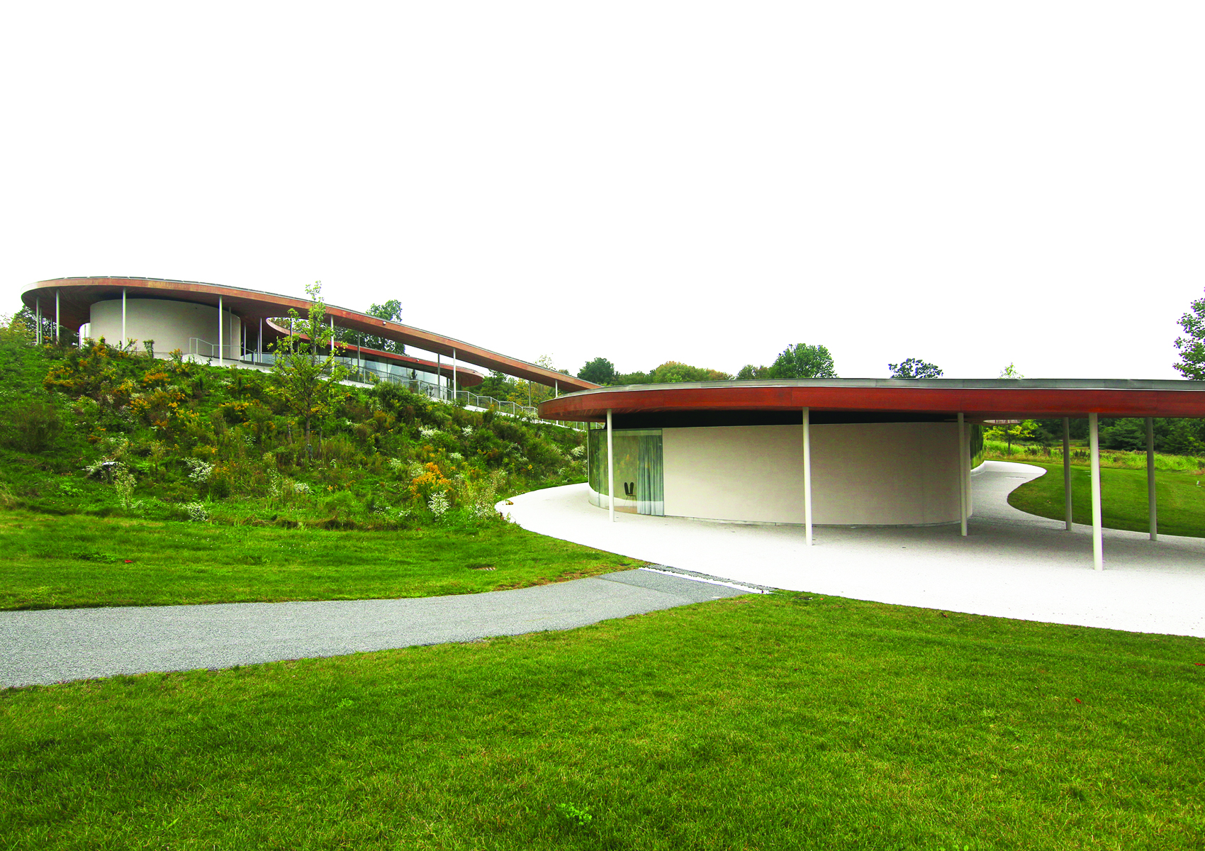 Modern winding architecture building, Grace Farms in New Canaan, Connecticut, RYUE NISHIZAWA / SANAA GRACE FARMS in pink font to upper left.