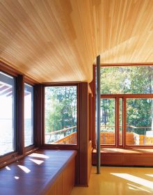 2 modern wooden buildings by Lake Muskoka, large trees and moss covered ground, The Architecture of Point William Shim Sutcliffe in white font to lower left.