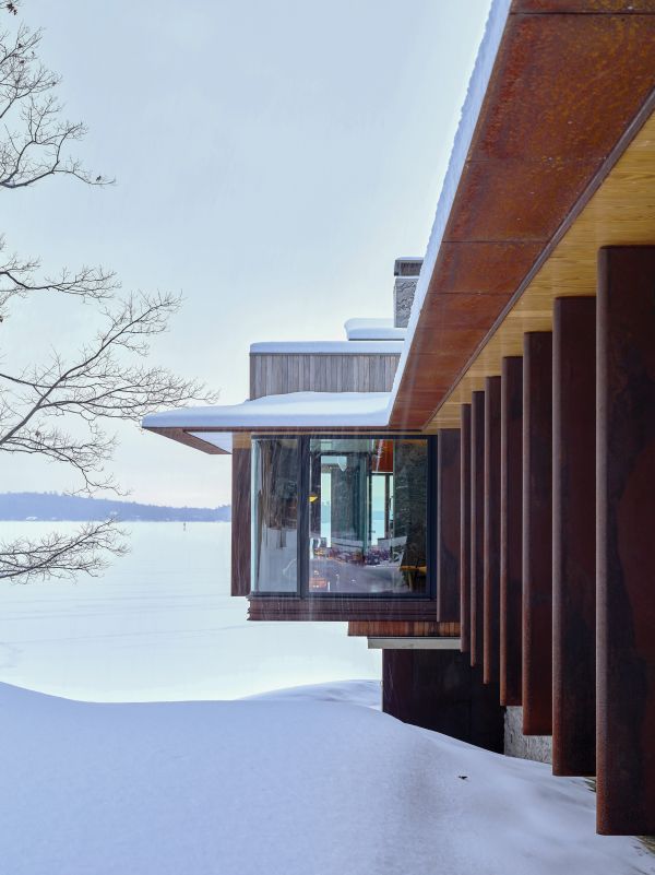 2 modern wooden buildings by Lake Muskoka, large trees and moss covered ground, The Architecture of Point William Shim Sutcliffe in white font to lower left.
