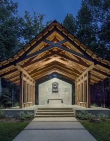 Building exterior with swimming pool below, on right side, girl peering through port hole in brick wall to left side, LIVE LEARN EAT in white font above.