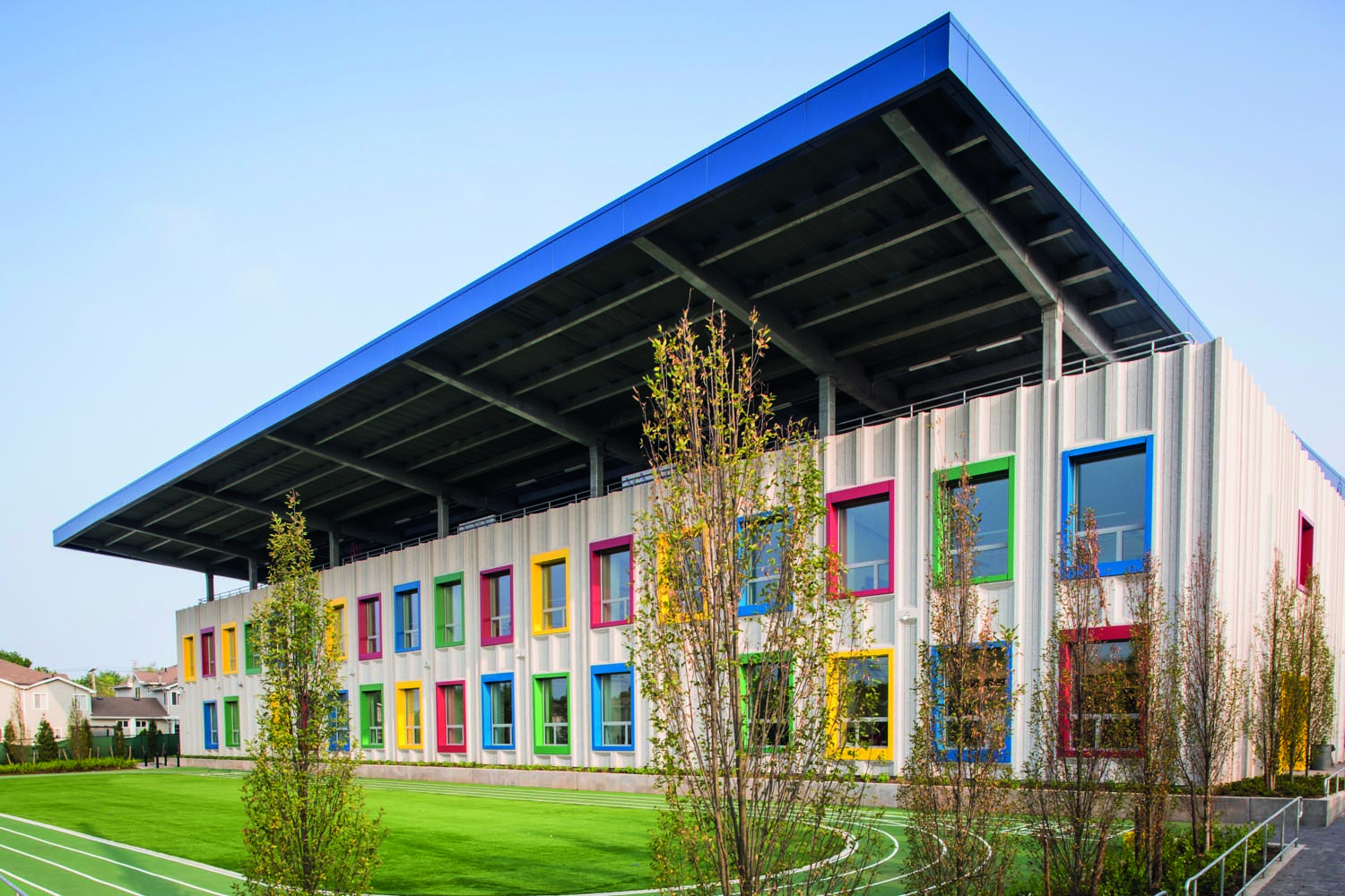 Elm tree elementary school, rainbow swirls on white tiled surface wall, Building Great Schools for a Great City in white font to upper left.