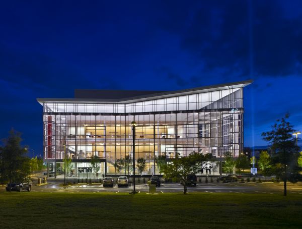 Modern glass residential building, under night sky, landscaped garden, TRIANGLE MODERN ARCHITECTURE in white font to top left.
