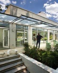 Modern glass residential building, under night sky, landscaped garden, TRIANGLE MODERN ARCHITECTURE in white font to top left.