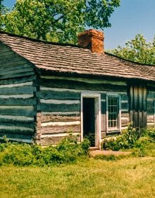 Stone dragon gargoyle on side of building, blue sky behind, ARCHES TO ZIGZAGS An Architectural ABC in white font above and below.