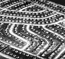 Straight road with yellow centre line, mountain landscape, image reflected above, Trans-Atlantic Engagements The Contribution and Impact of German Educators to US Architectural Education in white font.