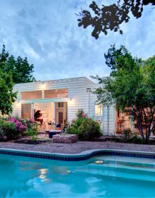 Single flat roof building illuminated by exterior lights under dusk blue sky with Framing The Valley in white font above