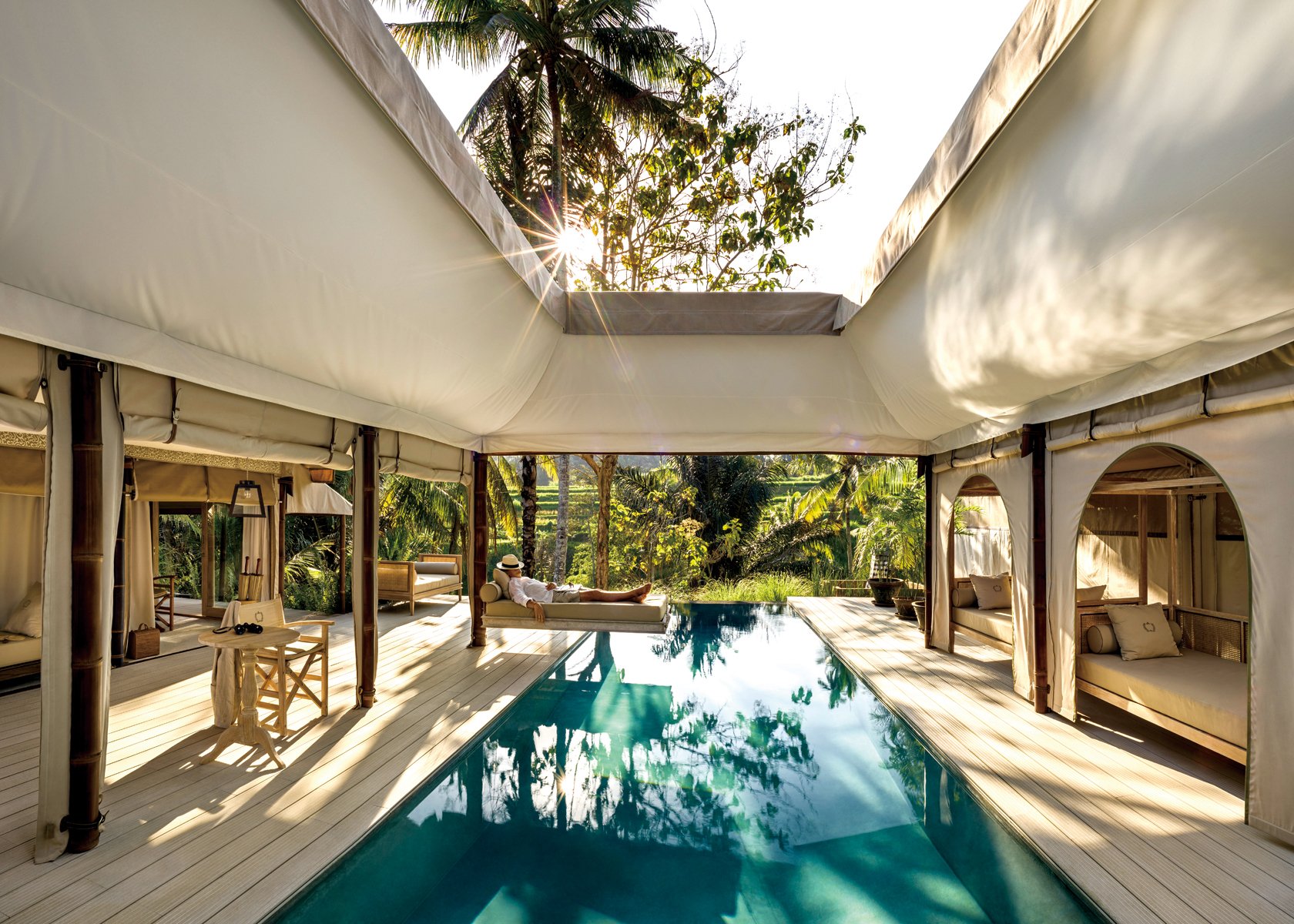 Serene infinity pool with swimmer, arched building structure surrounding, Haute Couture Architecture in white font to upper right