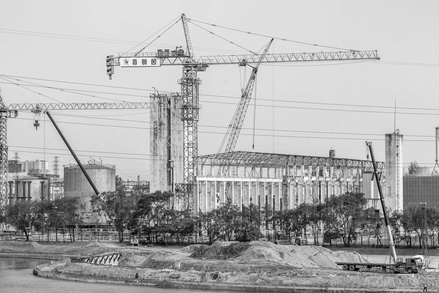 Exterior structure of derelict Shougang Oxygen Factory, THE STORY OF A SECTION in black font on white banner to left.