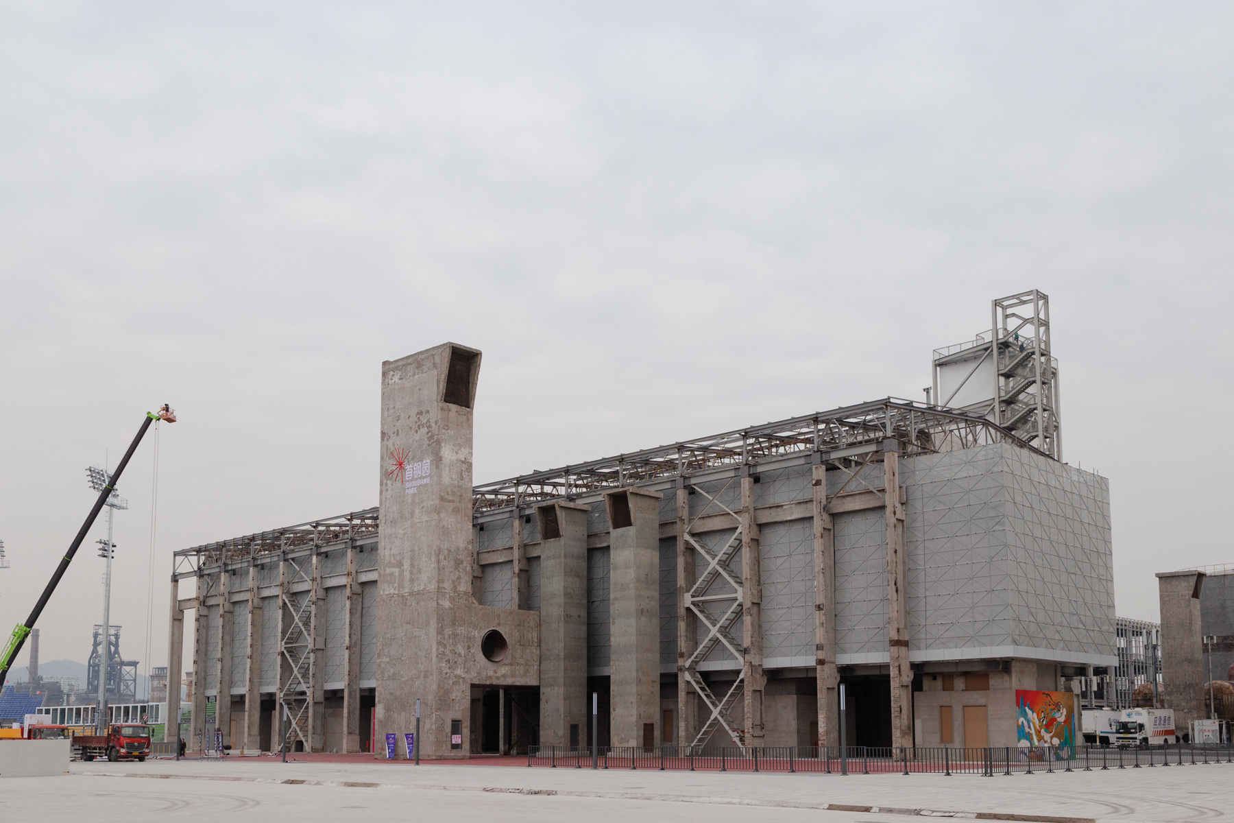 Exterior structure of derelict Shougang Oxygen Factory, THE STORY OF A SECTION in black font on white banner to left.