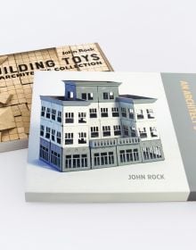 Wooden building blocks scored with grid lines, BUILDING TOYS AN ARCHITECT'S COLLECTION, in black font to upper right.