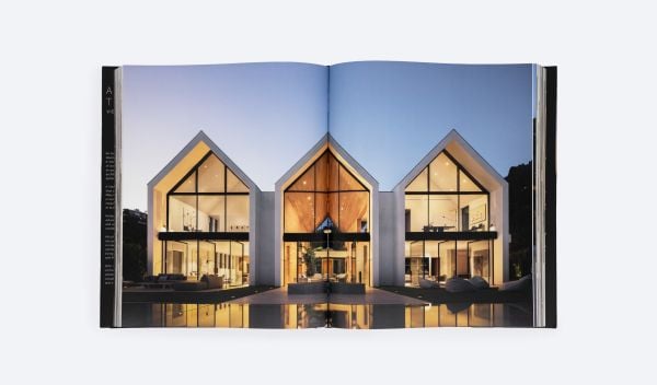 Modern, flat-roofed building with infinity pool and lounge chairs overlooking a green landscape. Published by ORO Editions.