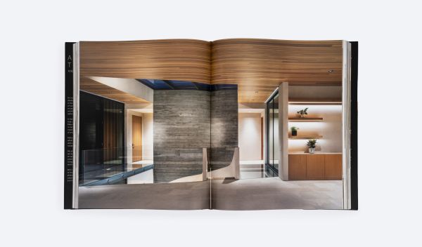 Modern, flat-roofed building with infinity pool and lounge chairs overlooking a green landscape. Published by ORO Editions.