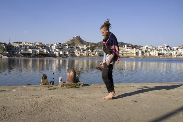 Book cover of David Zurick's Hippie India: Dreamers and Seekers in the Land of Nirvana, with a wall mural of two figures with their eyes closed. Published by ORO Editions.