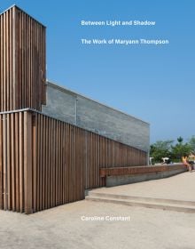 Book cover of Between Light and Shadow: The Work of Maryann Thompson, featuring a building with wood slates to exterior. Published by ORO Editions.