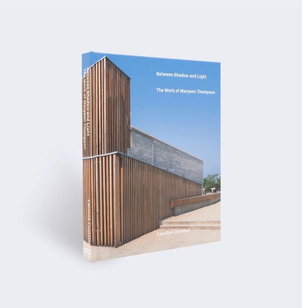 Book cover of Between Light and Shadow: The Work of Maryann Thompson, featuring a building with wood slates to exterior. Published by ORO Editions.