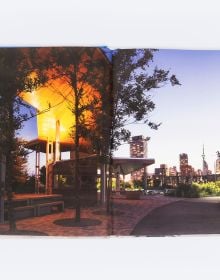 Book cover of Between Light and Shadow: The Work of Maryann Thompson, featuring a building with wood slates to exterior. Published by ORO Editions.