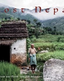 Book cover of Lost Nepal: A Photographic Memoir; featuring a figure standing in front of a hut with thatched roof, and misty mountains behind. Published by ORO Editions.