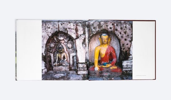 Book cover of Lost Nepal: A Photographic Memoir; featuring a figure standing in front of a hut with thatched roof, and misty mountains behind. Published by ORO Editions.