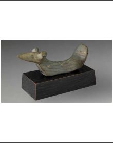 Dark stone bird like sculpture on grey background with Rêves de pierre Birdstones Dreams in stone in white green and black font above