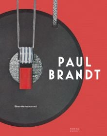 Red and grey pendant with diamond centre, on red cover of 'Paul Brandt', by Editions Norma.