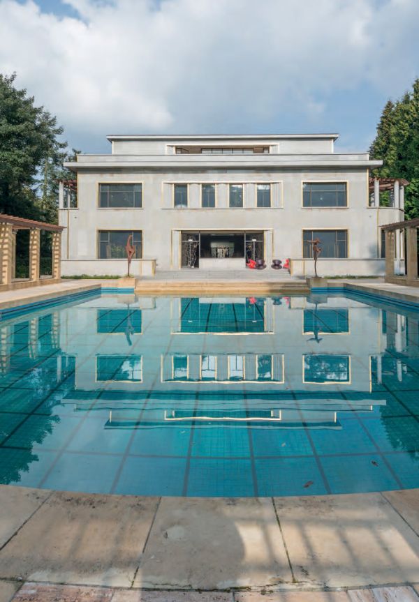 Flat roof building with swimming pool, brick front house with door below, on cover of 'Brussels Art Deco, Walks in the City Center', by Lannoo Publishers.