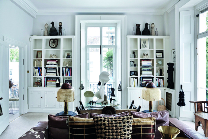 White curved sofa, with three wood stools, cream fire surround, on cover of 'Rendez-Vous Artists & Creatives at Home', by Beta-Plus.