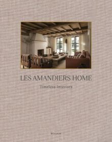 Linen book cover of Les Amandiers Home, Timeless Interiors, with interior living room with tan leather chairs, fireplace, and low wood coffee-table. Published by Beta-Plus.