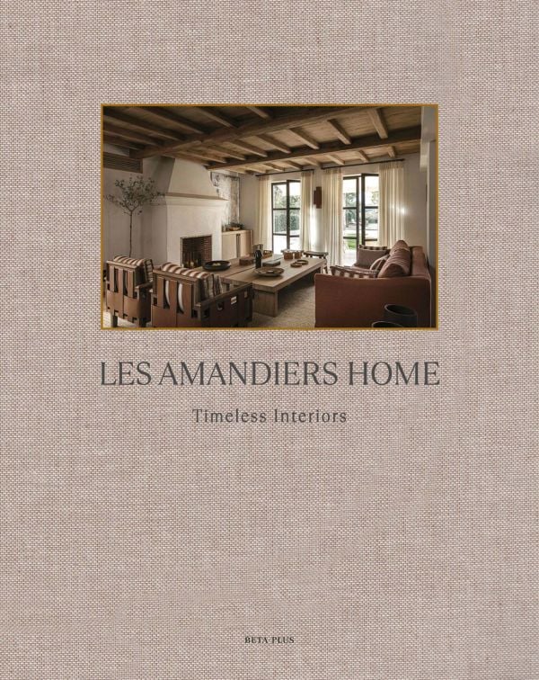 Linen book cover of Les Amandiers Home, Timeless Interiors, with interior living room with tan leather chairs, fireplace, and low wood coffee-table. Published by Beta-Plus.