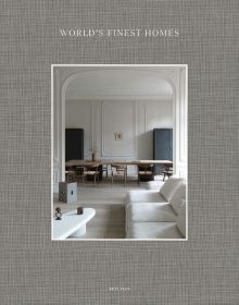 Pale interior space with white sofa, long dining table, on taupe linen cover, on cover of 'World's Finest Homes', by Beta-Plus.