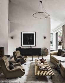 Pale interior space with white sofa, long dining table, on taupe linen cover, World's Finest Homes in white font above