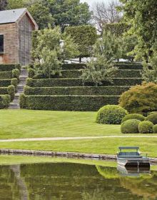 Green landscaped garden with curved waterway, on landscape cover of 'Michel Delvosalle Garden & Landscape Architect', by Beta-Plus.