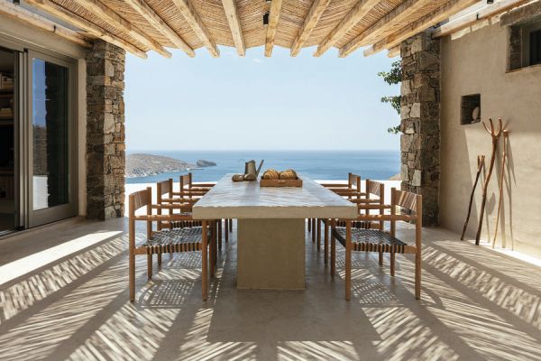 Book cover of Living by the Sea, with a table and chair near swimming pool, with sea view behind. Published by Beta-Plus.