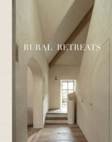 White interior hallway with archway, wood floor, RURAL RETREATS in white font above.