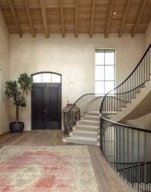 White interior hallway with archway, wood floor, RURAL RETREATS in white font above.