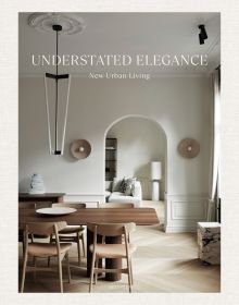Interior dining space with wood table and chairs, high ceiling, low light fitting, UNDERSTATED ELEGANCE New Urban Living in white font above.
