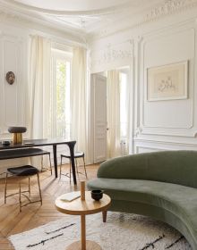 Interior dining space with wood table and chairs, high ceiling, low light fitting, UNDERSTATED ELEGANCE New Urban Living in white font above.