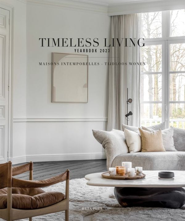 Book cover of Timeless Living Yearbook 2023, featuring a white and cream interior living room with a sofa and coffee table. Published by Beta-Plus.