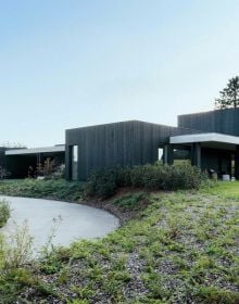 Dark grey interior with slate tiles, modern steel fireplace with logs on cover of 'Contemporary Living Yearbook 2023', by Beta-Plus.