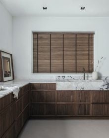 Interior bathroom with natural stone walls, sink below with wood surround, on cover of 'Nec Plus Ultra', by Beta-Plus.