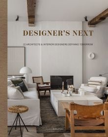 Interior living area with cream linen covered sofas, brown leather chairs, white walls, with ceiling beams, on cover of 'Designer's Next' by Beta-Plus.