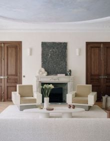 Interior living area with cream linen covered sofas, brown leather chairs, white walls, with ceiling beams, on cover of 'Designer's Next' by Beta-Plus.